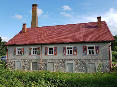 Traufseite der Wassermühle mit bemalten Fensterläden Historische Wassermühle von Zasa mit bemalten Fensterläden