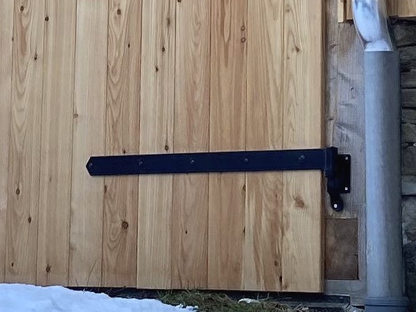 Detailansicht schwarzes Langband und Kloben am Scheunentor Kloben und Langbänder schawrz beschichtet bei einem Scheunentor